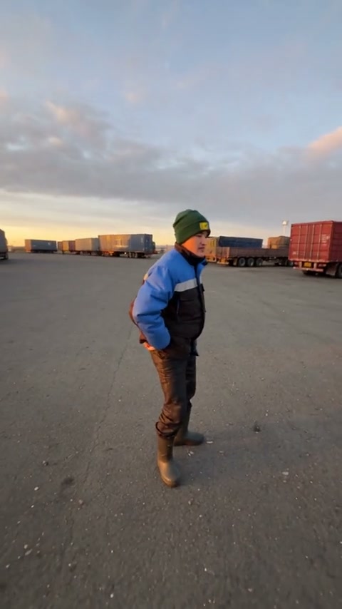 Community gas-station dance adaptation with a green-beanie performer in blue workwear