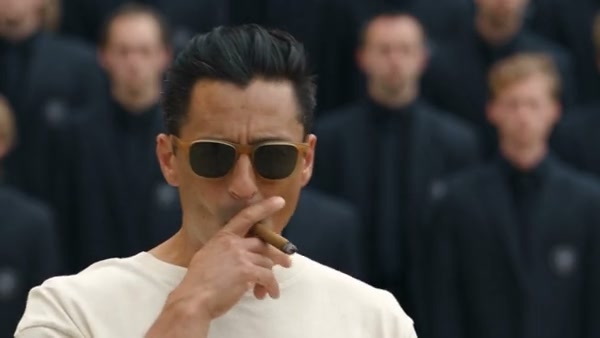 Community STORM II adaptation with a cream-shirted lead in sunglasses among dark-suited performers