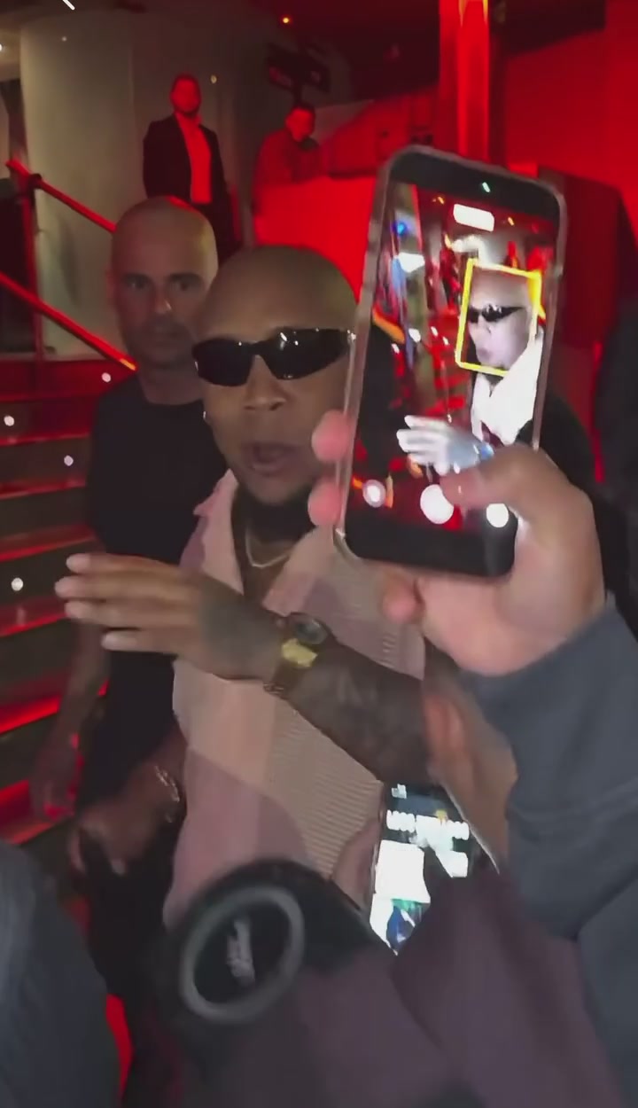 A phone crossing the source performer near the end of the clip